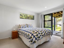 A bedroom with a bed and nightstand at The Cove Escape - Cooks Beach