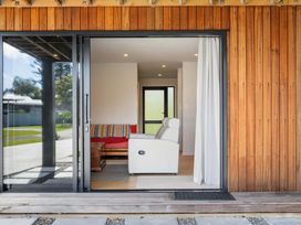 A living room with a sofa and chair at The Cove Escape - Cooks Beach