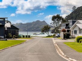 A view of houses and boats by the water at The Cove Escape - Cooks Beach