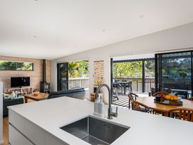 A kitchen with a sink and dining area at The Cove Escape - Cooks Beach