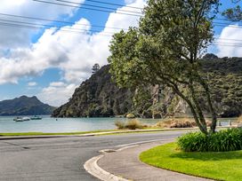 A view of water and boats near hills at The Cove Escape - Cooks Beach