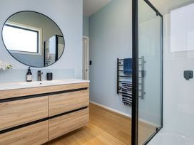 A bathroom with a sink and shower at The Cove Escape - Cooks Beach