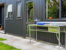 An outdoor area with a sink and water hose at The Cove Escape - Cooks Beach