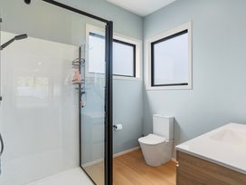 A bathroom with shower, toilet, and sink at The Cove Escape - Cooks Beach