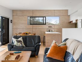 A living room with a sofa and coffee table at The Cove Escape - Cooks Beach
