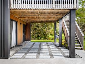 An outdoor area with a wooden deck and stairs at The Cove Escape - Cooks Beach
