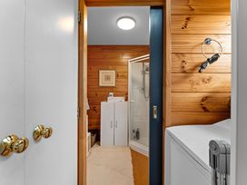 A bathroom with a shower and washing machine at Lakeside on Te Waaka - Kuratau Holiday Home Kuratau