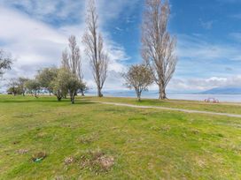 A park area with trees and a lake at Lakeside on Te Waaka - Kuratau