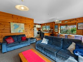 A living room with a sofa, coffee table, and a kitchen at Lakeside on Te Waaka - Kuratau Holiday Home, Kuratau