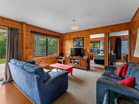 A living room with blue sofas and a TV at Lakeside on Te Waaka - Kuratau Holiday Home Kuratau