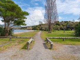 A pathway alongside a lake with trees and a table at Lakeside on Te Waaka - Kuratau