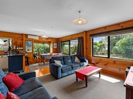 A living room with a sofa and dining area at Lakeside on Te Waaka - Kuratau