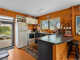 A kitchen with a refrigerator, stove, and sink at Lakeside on Te Waaka - Kuratau Holiday Home in Kuratau