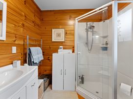 A bathroom with a shower, sink, and towel rack at Lakeside on Te Waaka - Kuratau