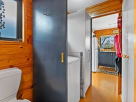 A bathroom with a toilet and washing machine at Lakeside on Te Waaka - Kuratau