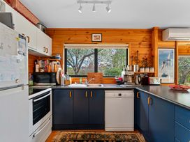 A kitchen with appliances and window at Lakeside on Te Waaka - Kuratau Holiday Home Kuratau
