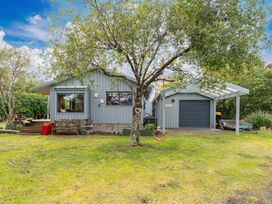 A house with a garage and tree in front at Lakeside on Te Waaka - Kuratau Holiday Home Kuratau