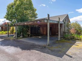 A house with a carport and tree at Fern View - Pukawa Bay Holiday Home Pukawa Bay