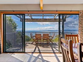 A dining room with glass doors leading to a deck at Fern View - Pukawa Bay Holiday Home Pukawa Bay