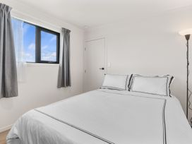 A bedroom with a bed and window at Over the Paddock - Waipu
