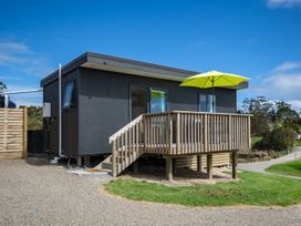 A house with a balcony and umbrella at Over the Paddock - Waipu