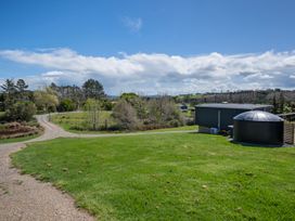 A view of a landscape with a road and trees at Over the Paddock - Waipu