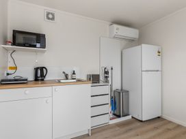 A kitchen with appliances and storage at Over the Paddock - Waipu