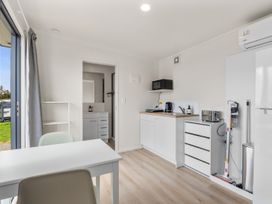 A kitchen with a table and appliances at Over the Paddock - Waipu