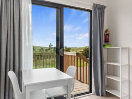 A dining area with a table and chairs at Over the Paddock - Waipu