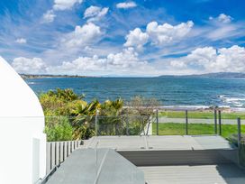 An outdoor area with decking overlooking the water at Hampton Cottage by the Lake - Taupo Central