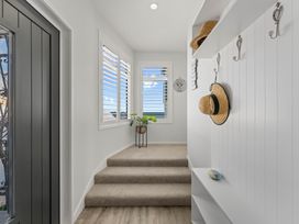 A hallway with stairs and wall hooks at Hampton Cottage by the Lake - Taupo Central