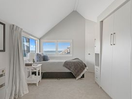 A bedroom with a bed and wardrobe at Hampton Cottage by the Lake - Taupo Central