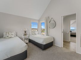A bedroom with two beds and a mirror at Hampton Cottage by the Lake - Taupo Central