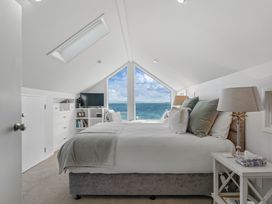 A bedroom with a bed and a window overlooking the sea at Hampton Cottage by the Lake - Taupo Central