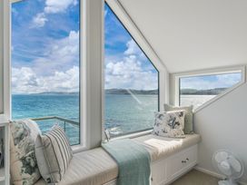 A living room with a seating area overlooking the water at Hampton Cottage by the Lake - Taupo Central