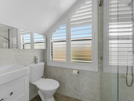 A bathroom with a sink, toilet, and shower at Hampton Cottage by the Lake - Taupo Central