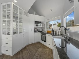 A kitchen with cabinets and appliances at Hampton Cottage by the Lake - Taupo Central