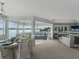 A dining area with a table and chairs and a living room at Hampton Cottage by the Lake - Taupo Central