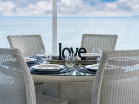 A dining table with settings and a decorative sign at Hampton Cottage by the Lake - Taupo Central