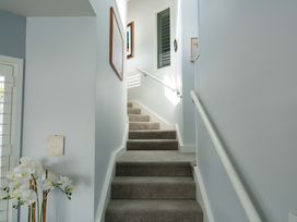 A staircase with a decorative plant and wall art at Hampton Cottage by the Lake - Taupo Central