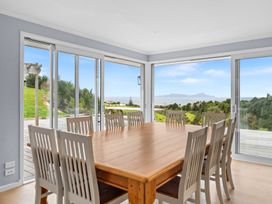 A dining room with a large table and chairs at Waipu Hilltop Escape - Waipu Cove