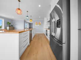 A kitchen with a refrigerator and an island at Waipu Hilltop Escape - Waipu Cove