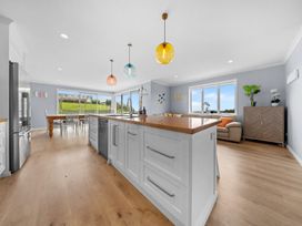A kitchen with an island and dining area at Waipu Hilltop Escape - Waipu Cove