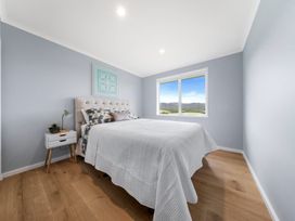 A bedroom with a bed and bedside table at Waipu Hilltop Escape - Waipu Cove