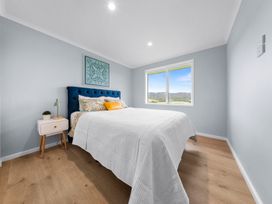 A bedroom with a bed and a bedside table at Waipu Hilltop Escape - Waipu Cove