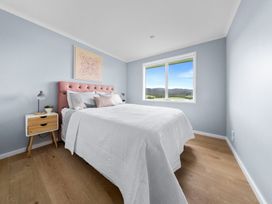 A bedroom with a bed and window at Waipu Hilltop Escape - Waipu Cove