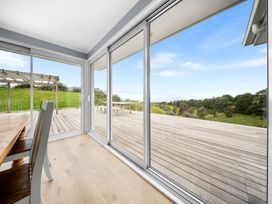 A dining area with a table and chairs at Waipu Hilltop Escape - Waipu Cove