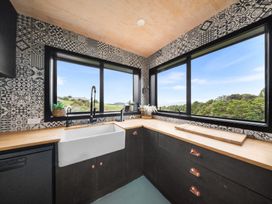 A kitchen with a large sink and windows at Waipu Hilltop Escape - Waipu Cove