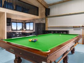 A game room with a pool table and refrigerator at Waipu Hilltop Escape - Waipu Cove