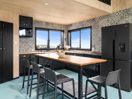 A kitchen with a large countertop and refrigerator at Waipu Hilltop Escape - Waipu Cove